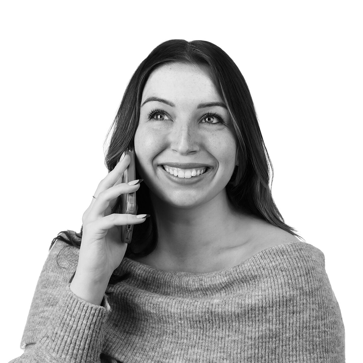 Smiling woman talking on a cell phone, looking up, wearing a gray knit sweater.